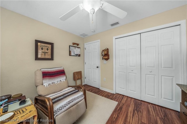 living area with a ceiling fan, baseboards, visible vents, and wood finished floors