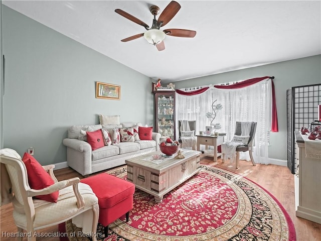 living room with ceiling fan, light hardwood / wood-style floors, and lofted ceiling