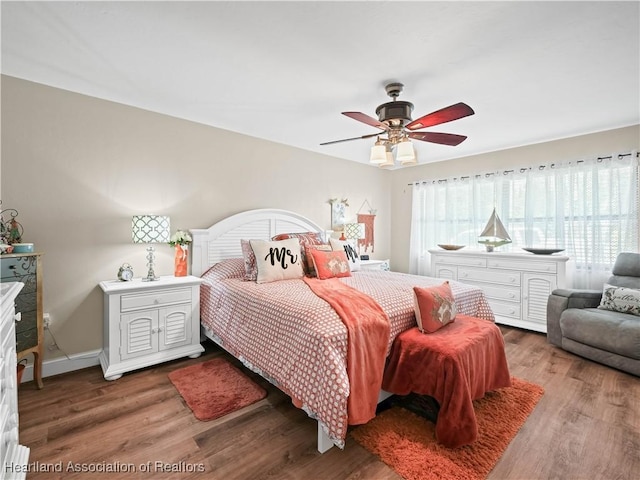 bedroom with dark hardwood / wood-style flooring and ceiling fan