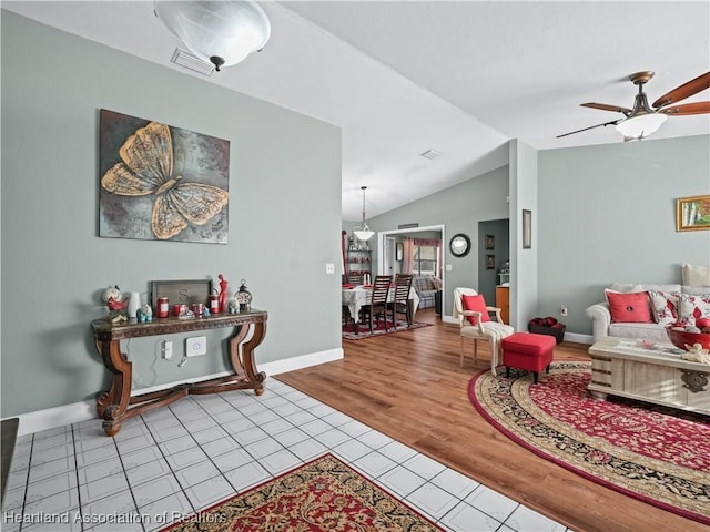 living room featuring light hardwood / wood-style floors, vaulted ceiling, and ceiling fan