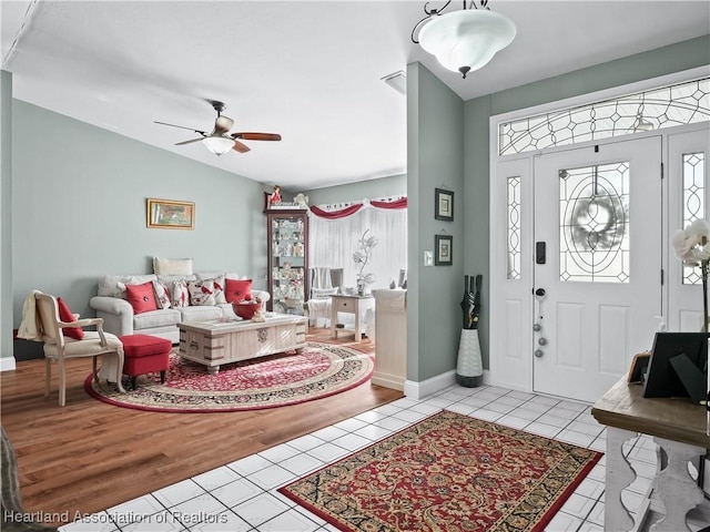 entrance foyer with ceiling fan, light tile patterned flooring, and lofted ceiling