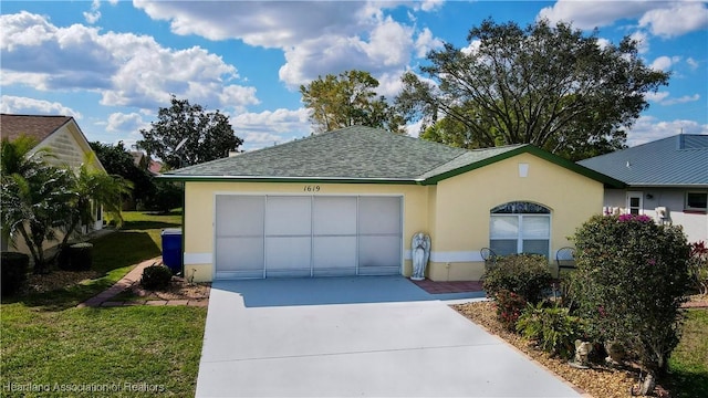 view of front of house featuring a garage, concrete driveway, roof with shingles, and stucco siding