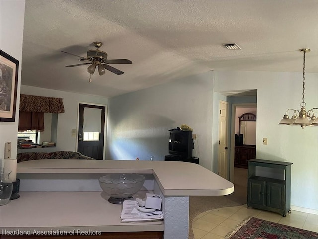 16 Notre Dame St, Lake Placid, FL 33852 - kitchen featuring a textured ceiling, ceiling fan with notable chandelier, light tile patterned floors, vaulted ceiling, and visible vents