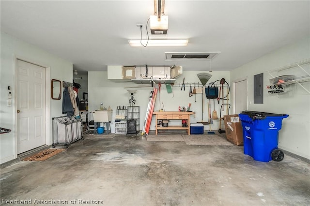 garage featuring electric panel, a garage door opener, and sink