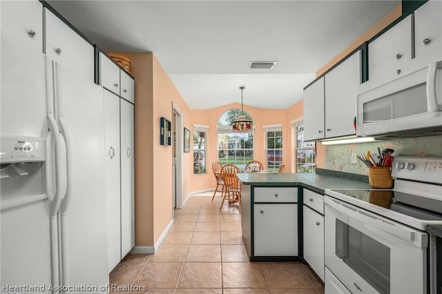 kitchen featuring white cabinetry, hanging light fixtures, lofted ceiling, white appliances, and light tile patterned floors