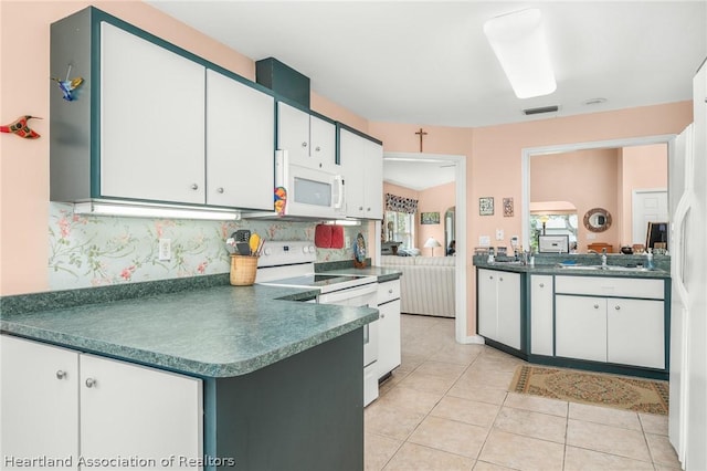 kitchen with white appliances, backsplash, white cabinets, sink, and light tile patterned flooring