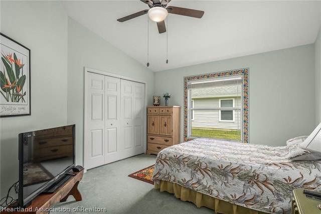 carpeted bedroom with a closet, lofted ceiling, and ceiling fan