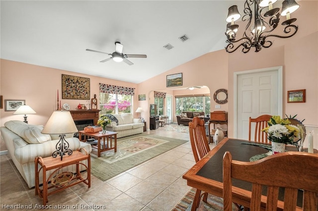 tiled living room with ceiling fan with notable chandelier and vaulted ceiling