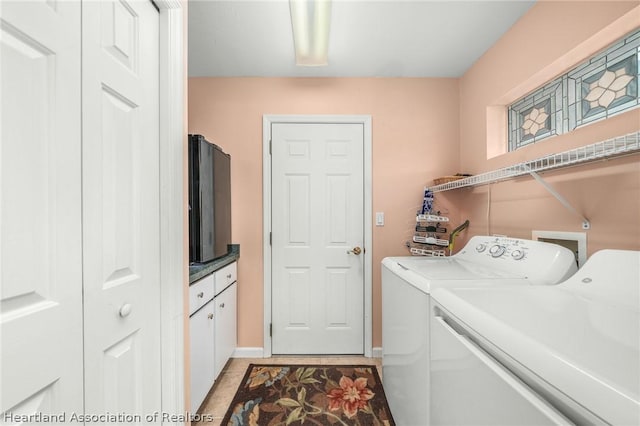 washroom with washing machine and clothes dryer and light tile patterned floors