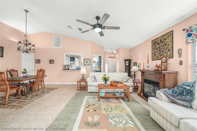 living room with lofted ceiling, light tile patterned floors, and ceiling fan with notable chandelier