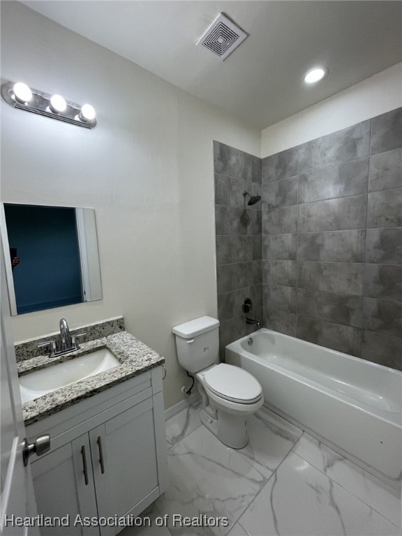 full bathroom with toilet, vanity, and tiled shower / bath