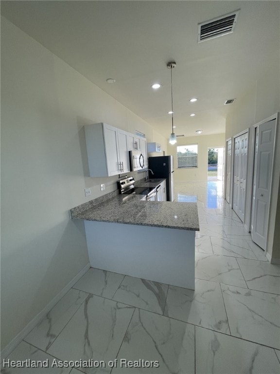 kitchen with light stone countertops, kitchen peninsula, pendant lighting, white cabinets, and appliances with stainless steel finishes