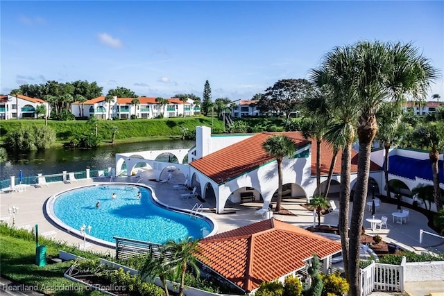 view of swimming pool featuring a water view and a patio