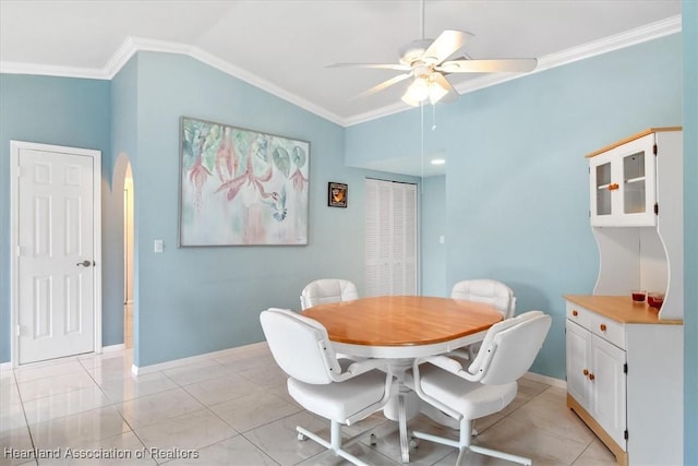 dining room with ceiling fan, ornamental molding, light tile patterned floors, and vaulted ceiling