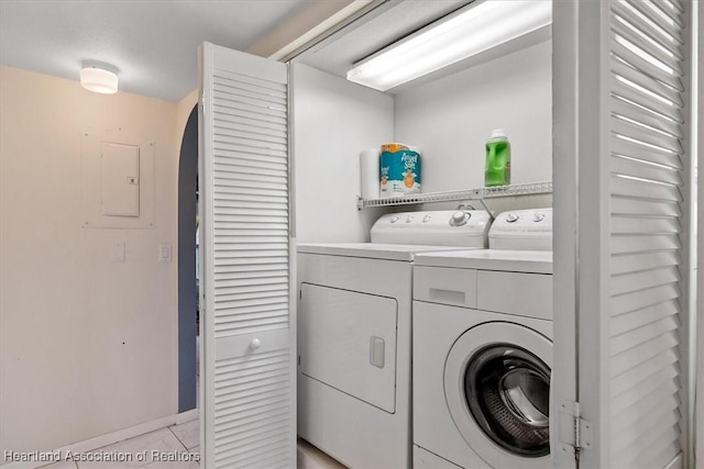 laundry area with separate washer and dryer and light tile patterned floors