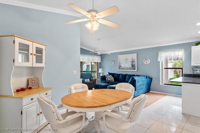 tiled dining room featuring ceiling fan and ornamental molding