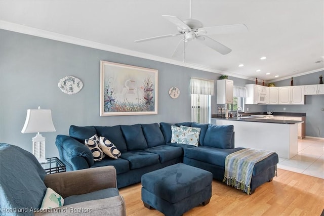 living room featuring crown molding, sink, ceiling fan, and light hardwood / wood-style floors