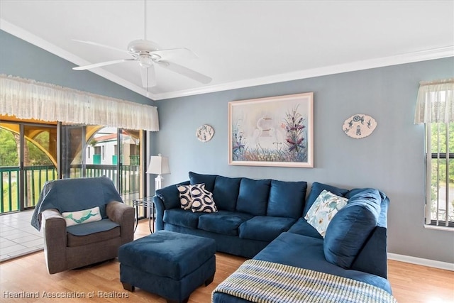 living room with a wealth of natural light, ceiling fan, vaulted ceiling, and hardwood / wood-style flooring