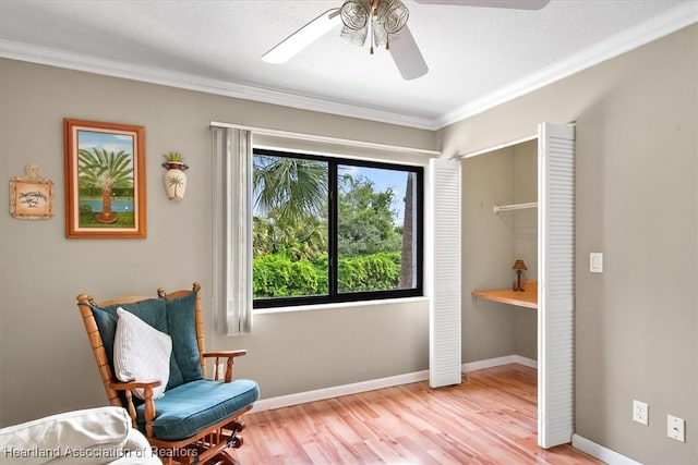 living area featuring light hardwood / wood-style flooring, ceiling fan, and crown molding