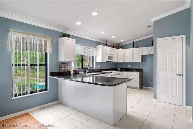 kitchen with white cabinets, white appliances, kitchen peninsula, and crown molding