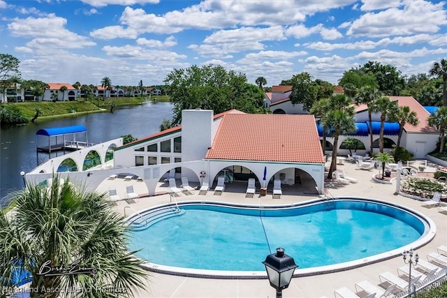 view of pool featuring a water view and a patio