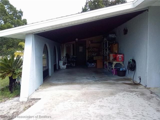 garage featuring a carport and concrete driveway
