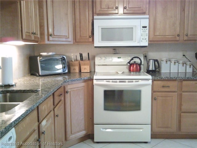 kitchen with white appliances, dark stone counters, backsplash, and a toaster