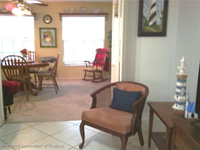 tiled dining room with carpet and ceiling fan