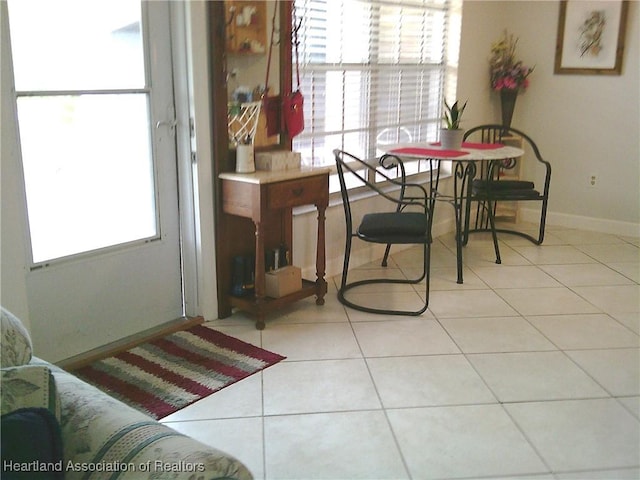 dining room with light tile patterned floors, baseboards, and plenty of natural light