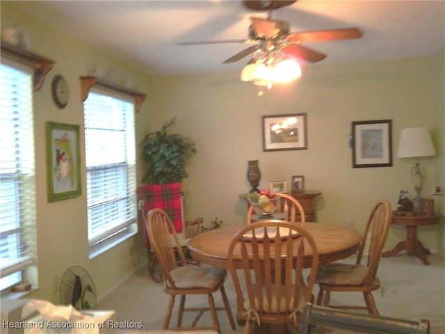 carpeted dining area featuring baseboards and a ceiling fan