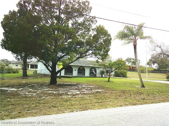 view of front of house with a front yard and fence