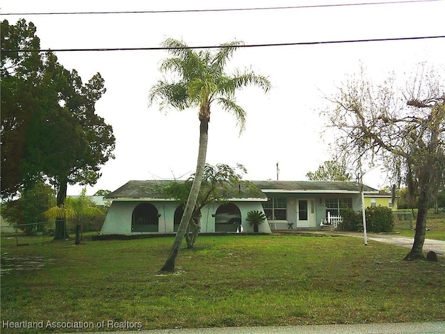 ranch-style home featuring a front yard and fence