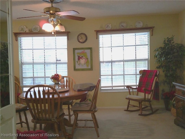 carpeted dining area featuring baseboards and a ceiling fan