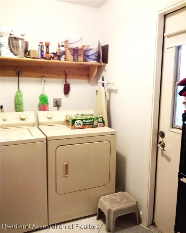 laundry room with light tile patterned flooring, washing machine and dryer, and laundry area