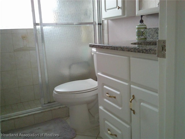 full bathroom with vanity, a shower stall, and toilet