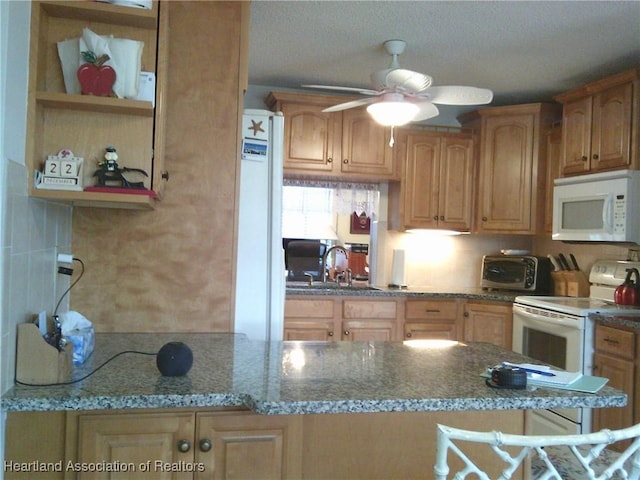 kitchen with ceiling fan, a toaster, stone counters, white appliances, and a sink