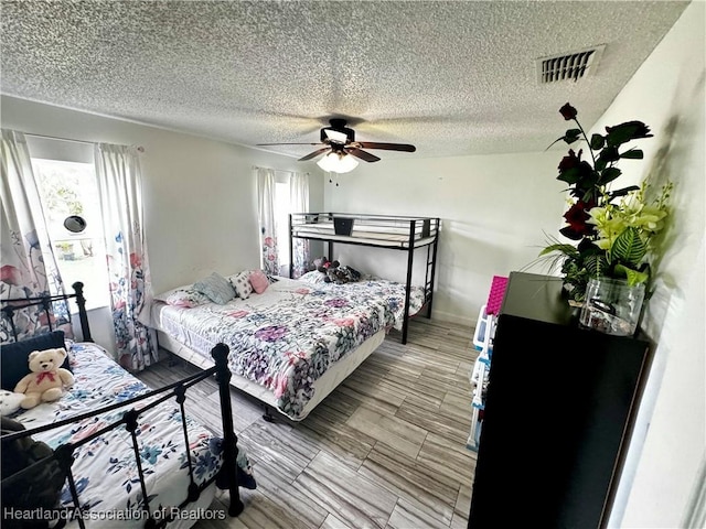 bedroom with a textured ceiling and ceiling fan