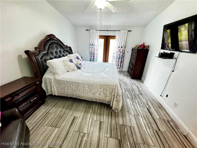 bedroom with ceiling fan, light hardwood / wood-style floors, and a textured ceiling