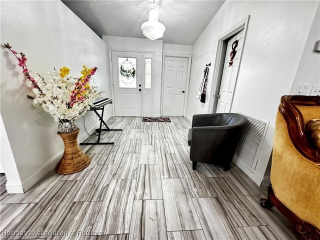 foyer entrance featuring light wood-type flooring and a textured ceiling