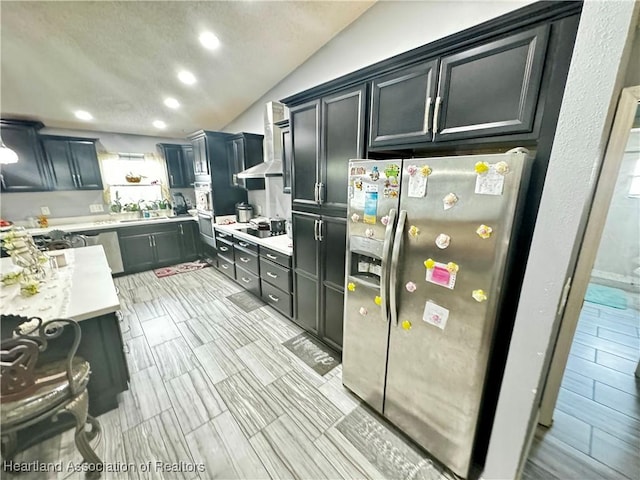 kitchen with lofted ceiling, wall chimney range hood, sink, black electric cooktop, and stainless steel fridge with ice dispenser