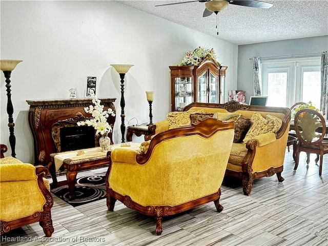 living area with ceiling fan and a textured ceiling