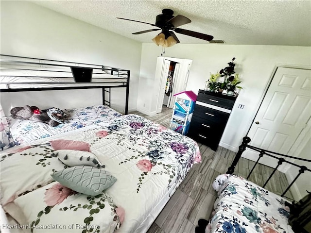 bedroom featuring wood-type flooring, a textured ceiling, a closet, and ceiling fan