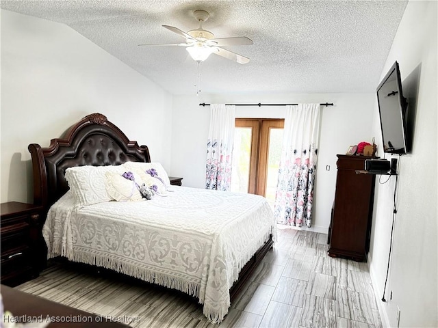 bedroom with a textured ceiling, ceiling fan, and lofted ceiling