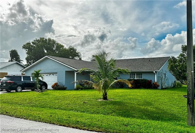 ranch-style house featuring a garage and a front lawn