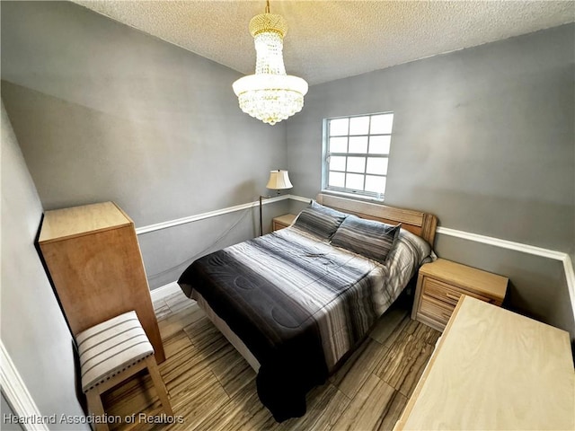 bedroom with a textured ceiling and a notable chandelier