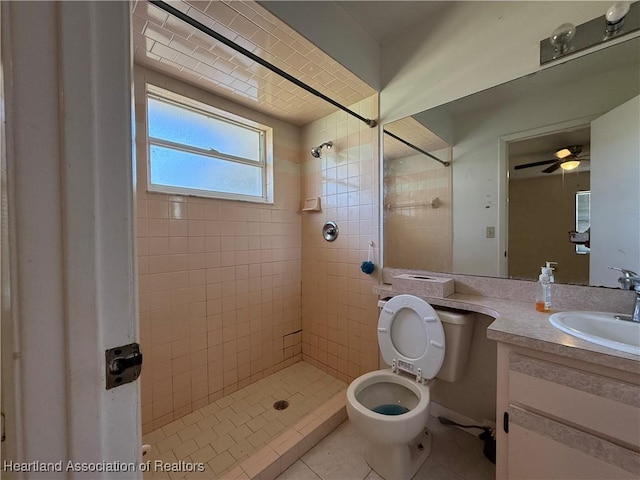 full bathroom with toilet, vanity, tile patterned flooring, and a tile shower