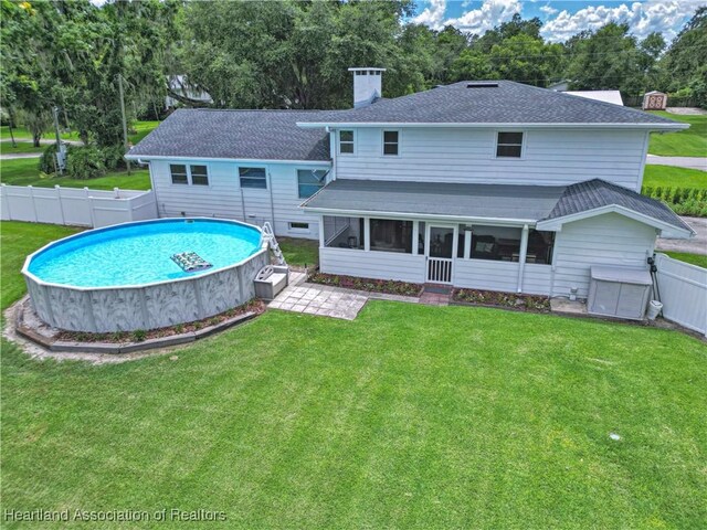 1244 Kelly Ct, Wauchula, FL 33873 - rear view of property with a sunroom, a chimney, a fenced backyard, and roof with shingles