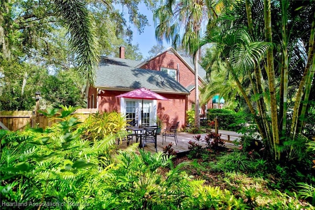 1237 Hotiyee Ave, Sebring, FL 33870 - rear view of property featuring a deck, a shingled roof, and a chimney