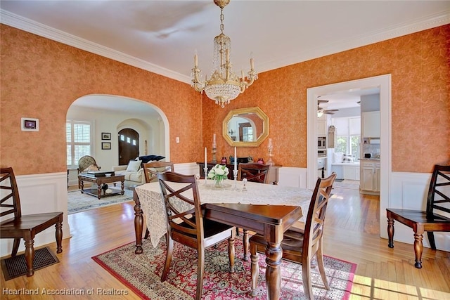 1237 Hotiyee Ave, Sebring, FL 33870 - dining room featuring healthy amount of natural light, arched walkways, a chandelier, wallpapered walls, and wainscoting