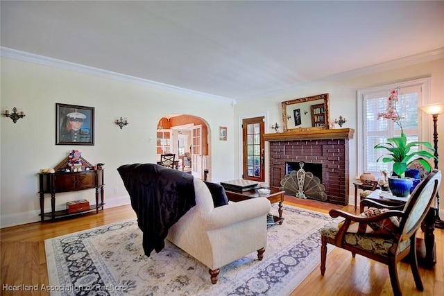 1237 Hotiyee Ave, Sebring, FL 33870 - living room with arched walkways, crown molding, plenty of natural light, a brick fireplace, and wood finished floors